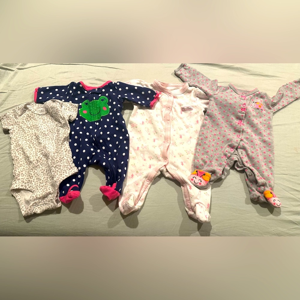 Four newborn baby onesies.